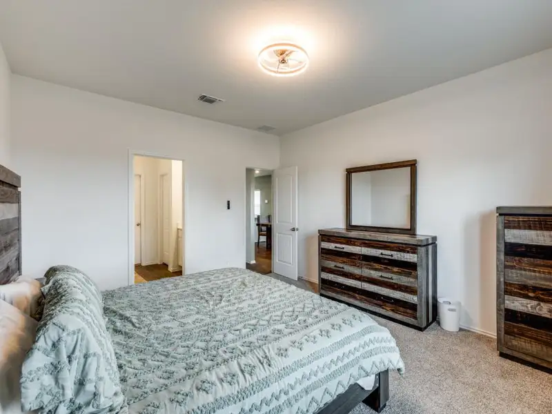 Bedroom featuring light carpet and baseboards