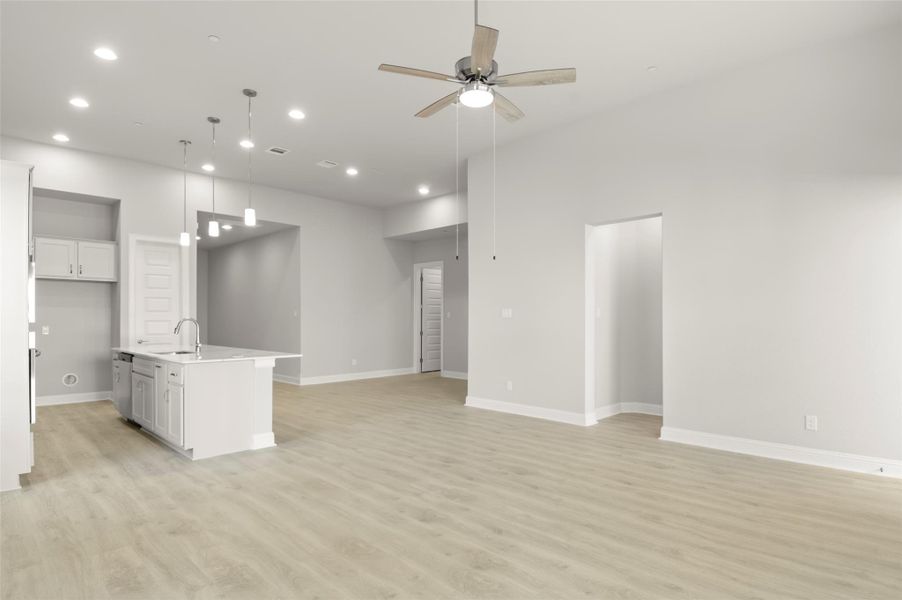 Unfurnished living room with light wood finished floors, ceiling fan, and recessed lighting Unfurnished living room with light wood finished floors, ceiling fan, and recessed lighting