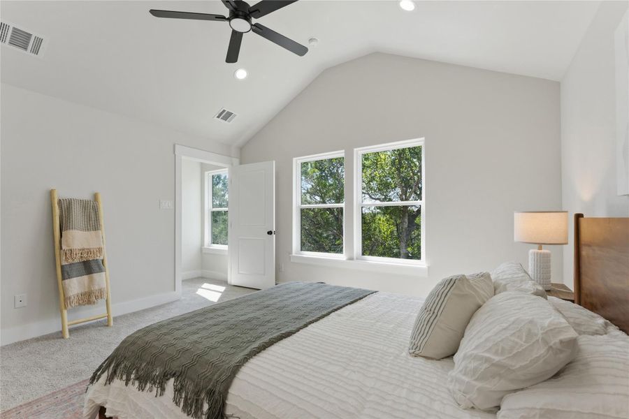 Another of the primary bedroom. A private nest in the trees, with large windows overlooking the greenspace. Tucked upstairs as the home's only second-level room, it offers a peaceful retreat with privacy from the rest of the home.