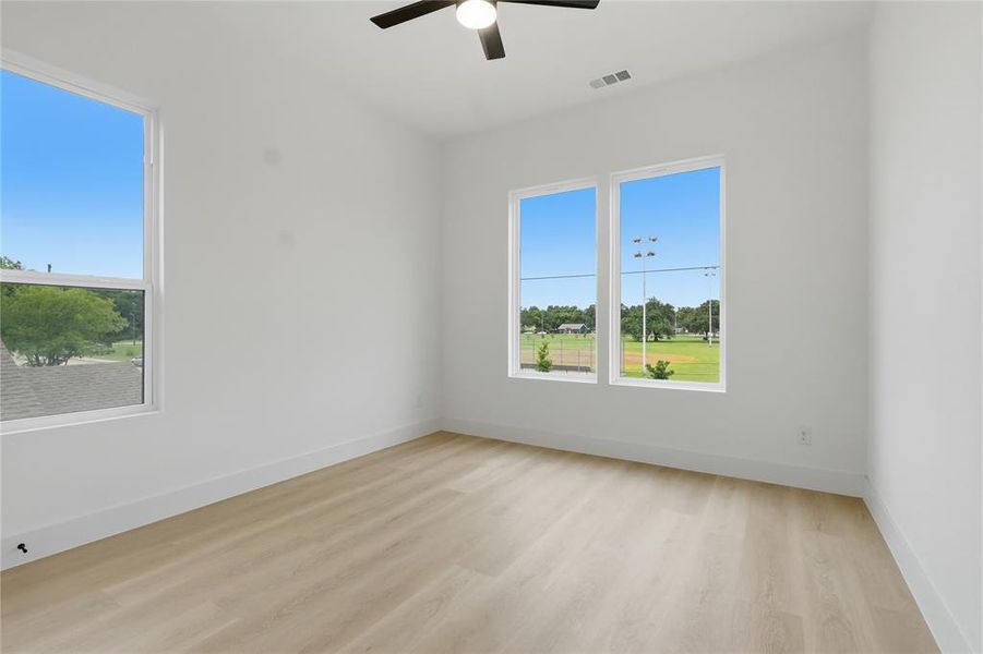Bright room featuring light wood-finish flooring and pristine white walls Bright room featuring light wood-finish flooring and pristine white walls