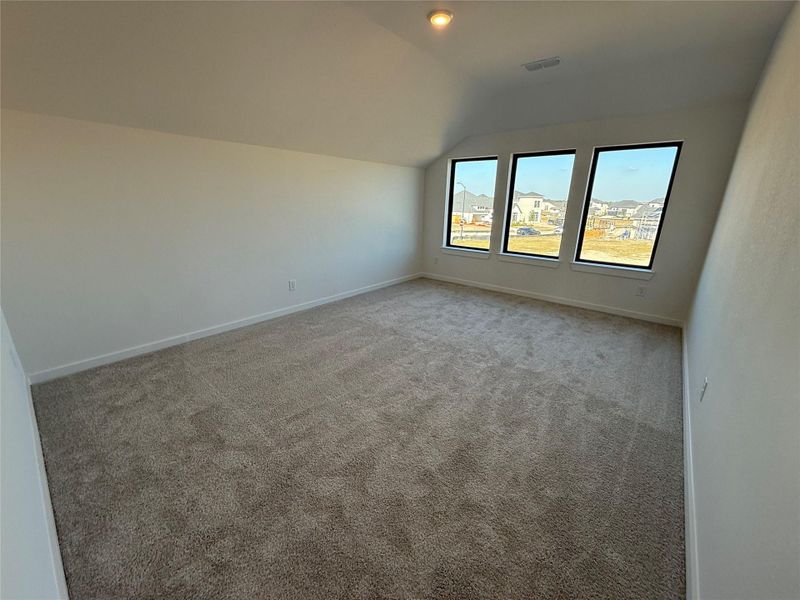 This upstairs gameroom offers a lively space for entertainment, filled with room for games, a pool table, and activities. Large windows keep the area bright.