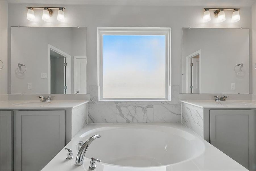Bathroom featuring two vanities and a garden tub Bathroom featuring two vanities and a garden tub