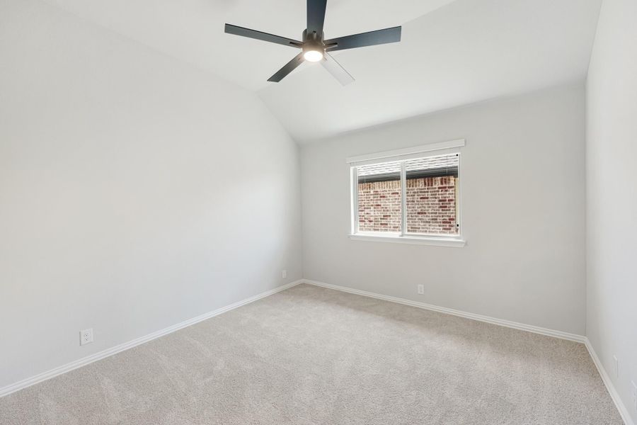 Empty bedroom with vaulted ceiling, ceiling fan, carpet flooring, and single window