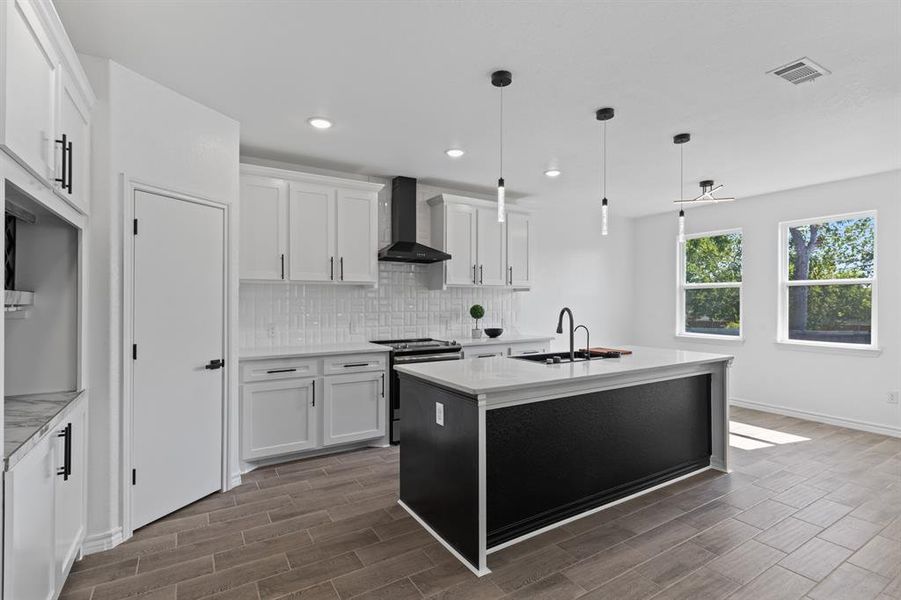 Kitchen featuring backsplash, electric range, and white cabinetry