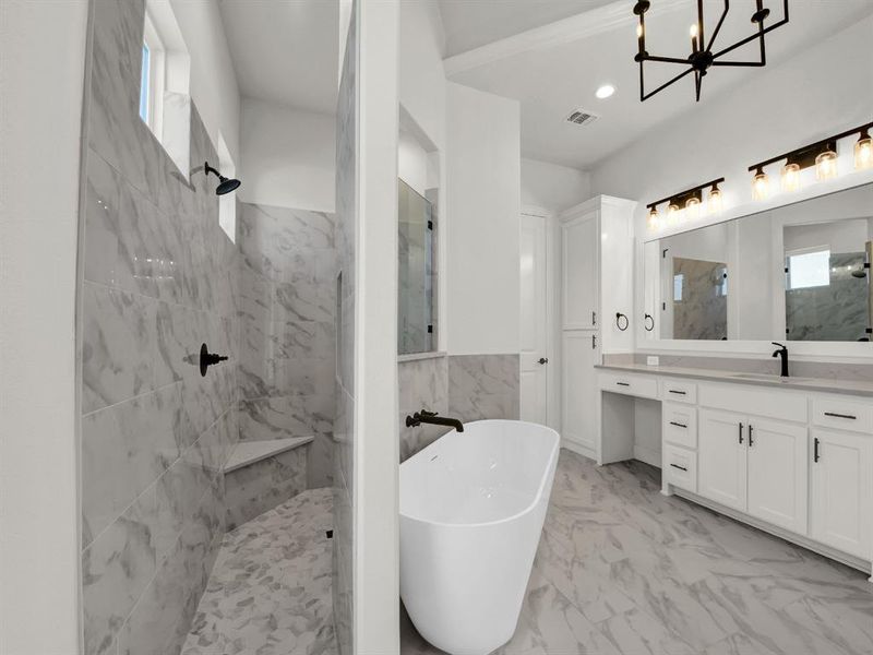 Bathroom featuring vanity, plus walk in shower, and a chandelier