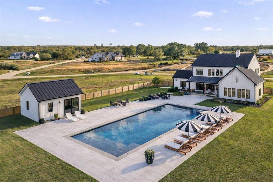 View of backyardwith outdoor living/dining patio. Rendering of swimming pool and exterior structure View of backyardwith outdoor living/dining patio. Rendering of swimming pool and exterior structure