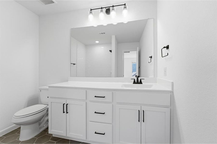 Bathroom featuring a dual-sink vanity with white cabinetry, matte black hardware, and a white countertop