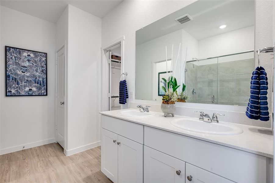 Bathroom with hardwood / wood-style floors, vanity, and a shower with shower door