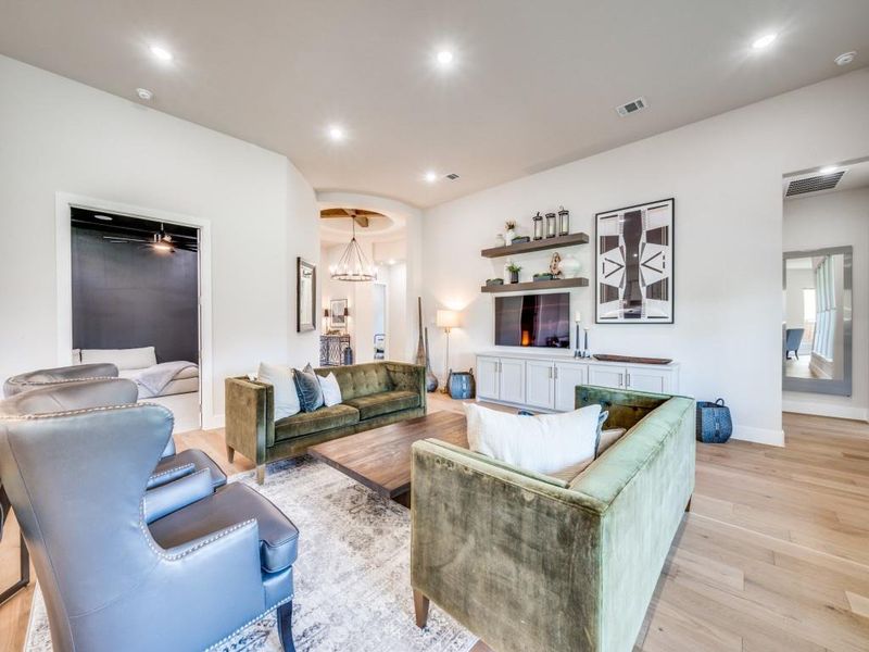 Living area featuring light wood-type flooring, recessed lighting, baseboards, and a chandelier