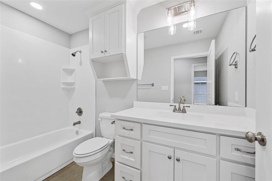 Full bath featuring visible vents, toilet, shower / bathing tub combination, and vanity