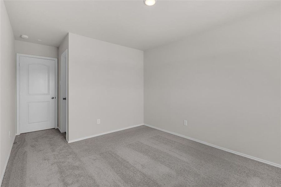 This is the 3rd bedroom angled view that's neutral-toned. Featuring plush carpeting, recessed lighting, and ready for personalization.