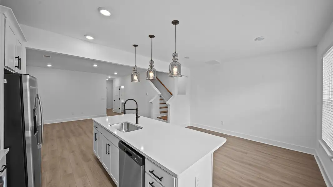 Accomplished kitchen design featuring pendant lighting above a statement island for both prep and gathering