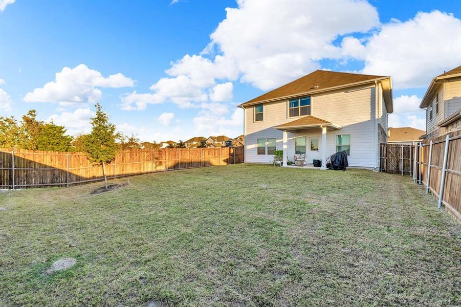 Rear view of property with a yard