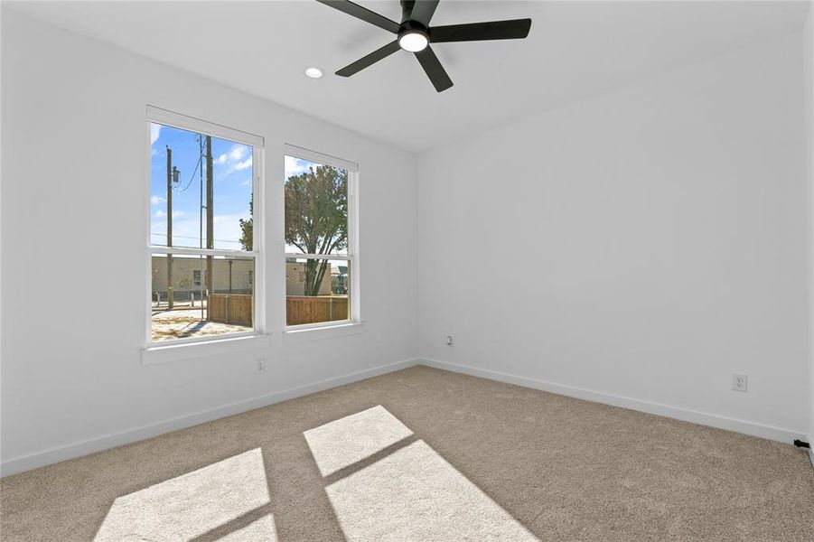 Unfurnished room featuring light carpet and a ceiling fan Unfurnished room featuring light carpet and a ceiling fan