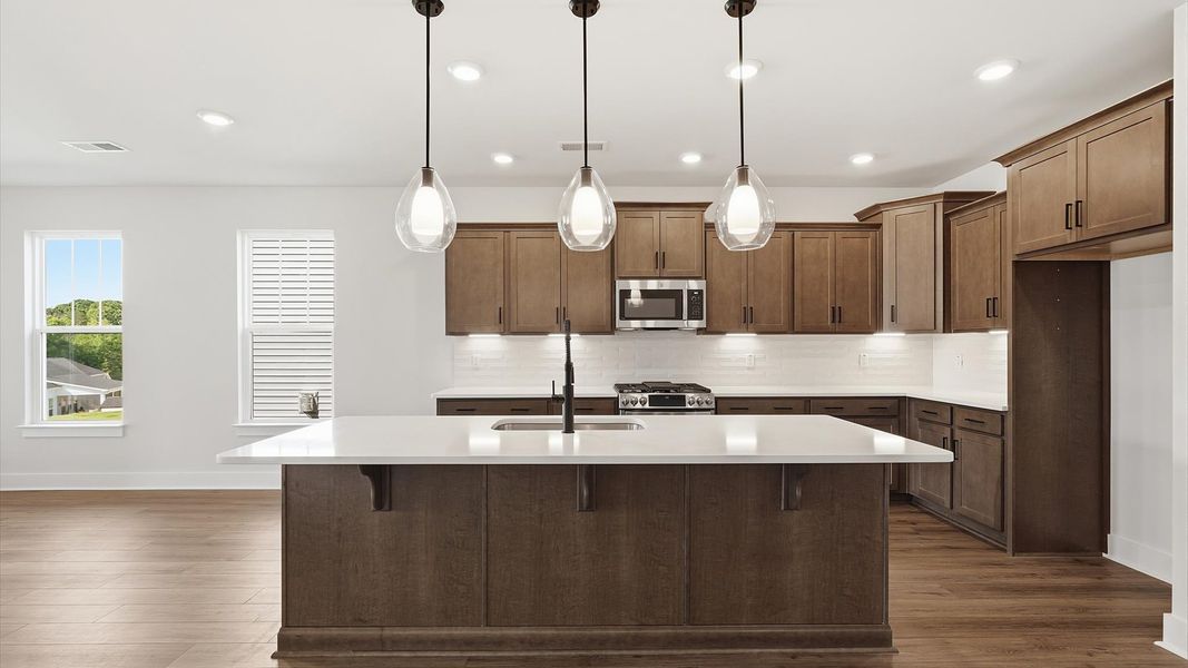 Elegant kitchen featuring a 9-foot island with pendant lighting and tasteful finishes throughout in Moore, SC Elegant kitchen featuring a 9-foot island with pendant lighting and tasteful finishes throughout in Moore, SC