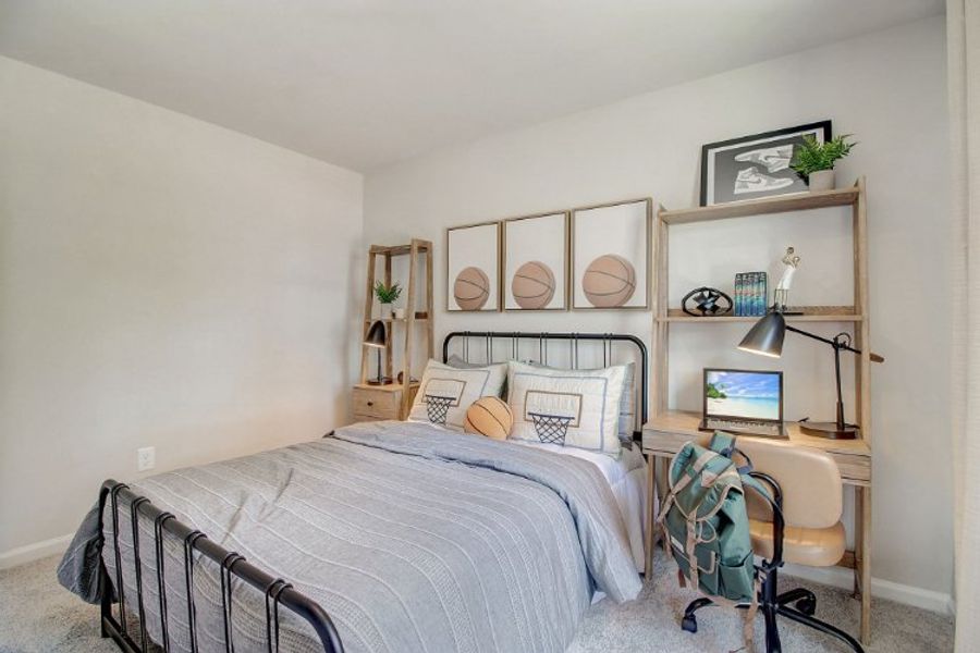 A bedroom with a bed desk and a laptop. A bedroom with a bed desk and a laptop.