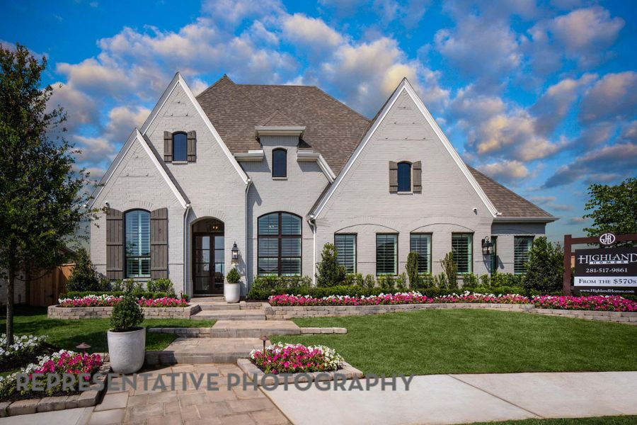 French country home with a shingled roof, a front lawn, and brick siding French country home with a shingled roof, a front lawn, and brick siding