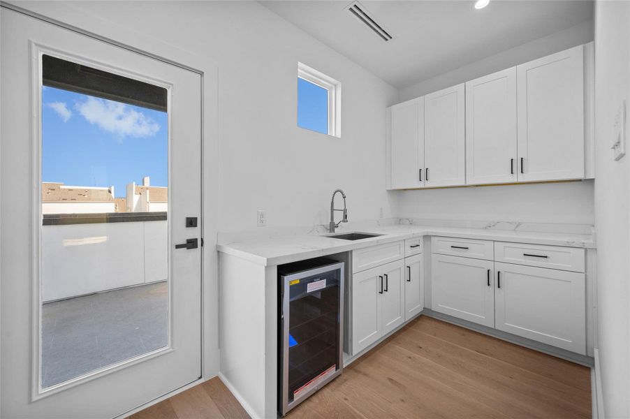 View of wet bar area with beverage fridge by Game Room