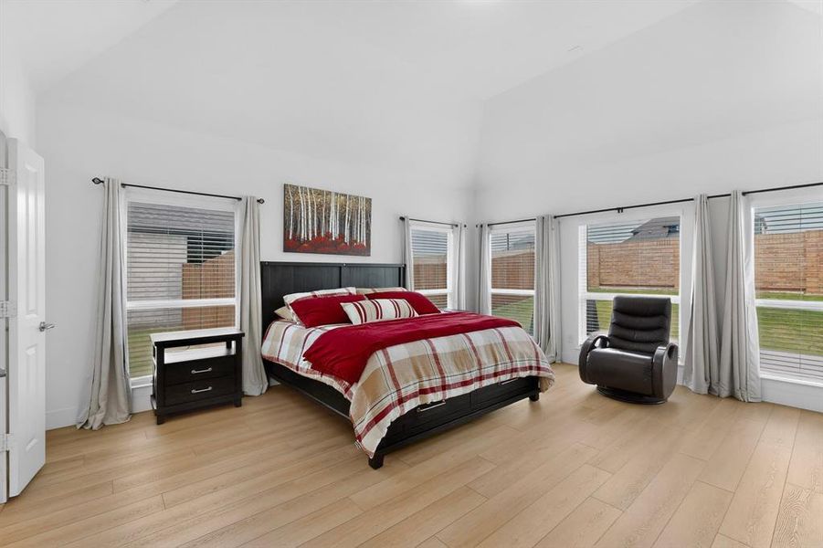 Spacious room featuring a vaulted ceiling and light wood-finish flooring Spacious room featuring a vaulted ceiling and light wood-finish flooring