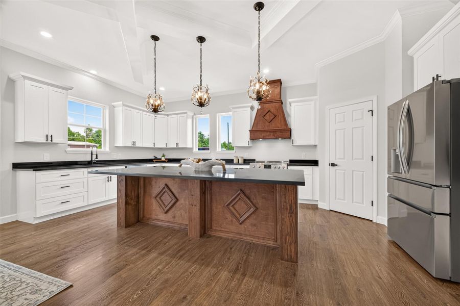 Custom kitchen featuring beautiful cabinetry, generous counter space, and an oversized center island.