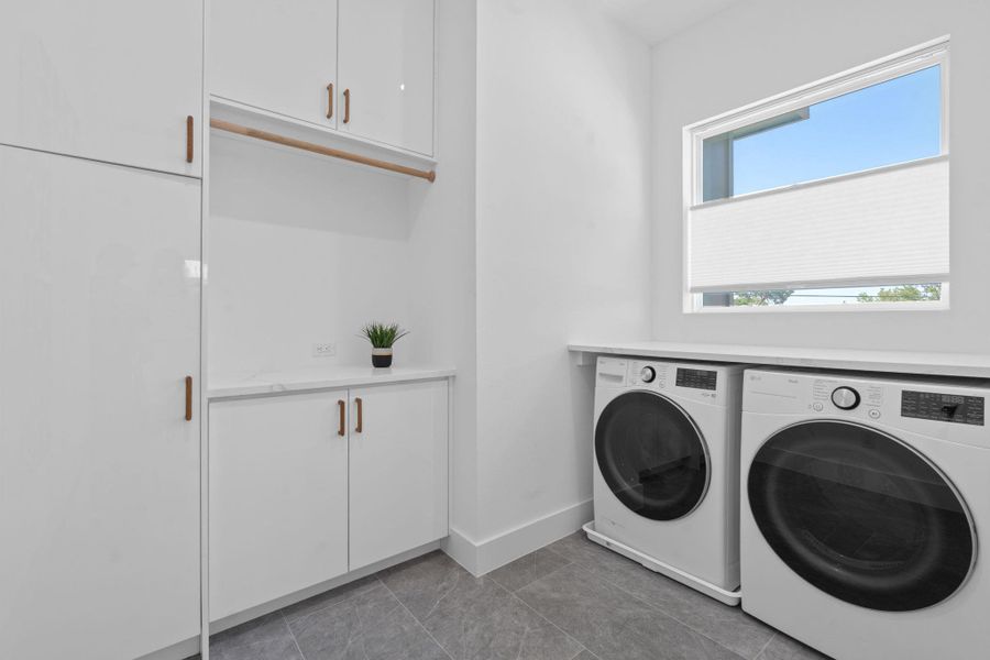 Functional and polished, this laundry room offers generous storage and a streamlined setup. Functional and polished, this laundry room offers generous storage and a streamlined setup.