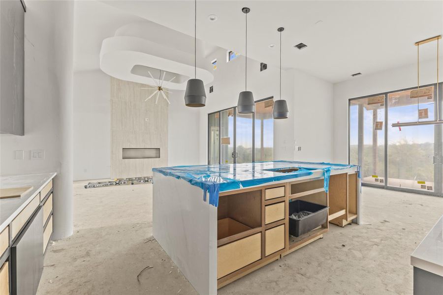 Kitchen island with partially installed cabinetry, under-mount sink, and protective countertop covering