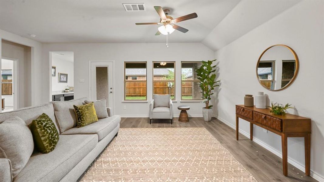 Living area featuring lofted ceiling, ceiling fan, and wood finished floors