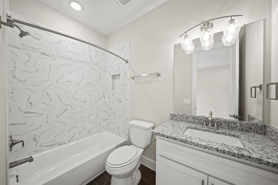 Secondary Bathroom with tile floors, a shower/tub combo with recessed lighting, granite countertops, and a large mirror.