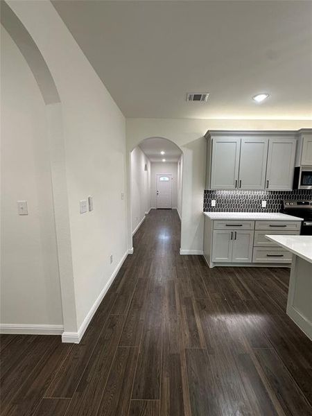 Kitchen featuring tasteful backsplash, dark hardwood / wood-style flooring, stainless steel appliances, and gray cabinetry