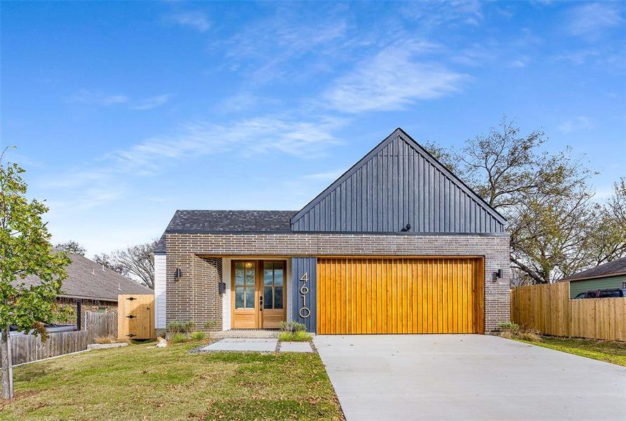 Modern home featuring brick siding and concrete driveway