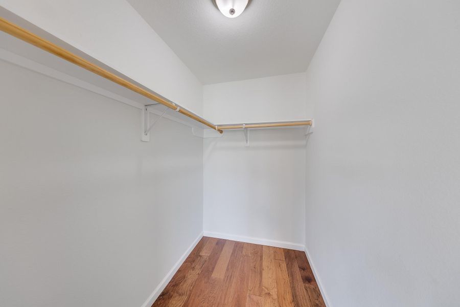 This walk-in closet offers storage and organization, providing the perfect dedicated space for your entire wardrobe collection.
