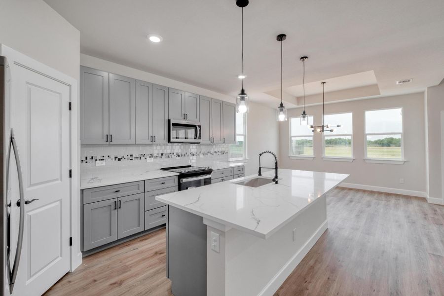 Kitchen featuring gray cabinetry, stainless steel appliances, a sink, light wood-style flooring, and recessed lighting