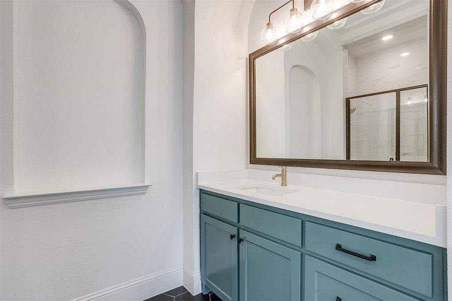 Bathroom featuring tile floors, walk in shower, and vanity with extensive cabinet space