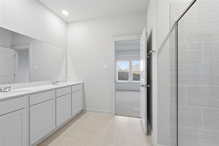 Bathroom featuring a dual vanity with white cabinetry and countertops, a large mirror, and recessed lighting Bathroom featuring a dual vanity with white cabinetry and countertops, a large mirror, and recessed lighting