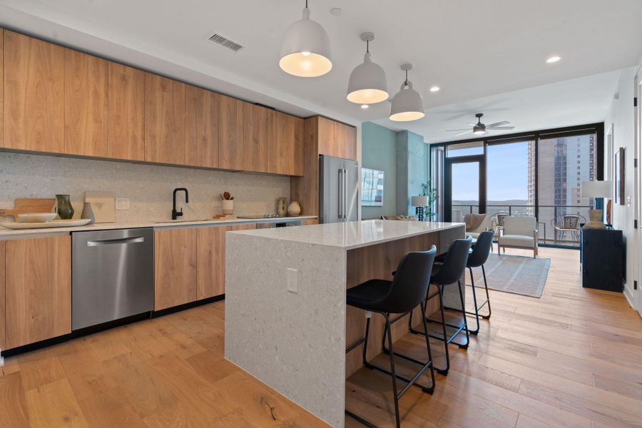 Representative Photo. Kitchen featuring custom Italkraft cabninetry, terrazzo backsplash, waterfall-edge terrazzo countertops, stainless steel Bosch appliances, and pendant lighting above kitchen island