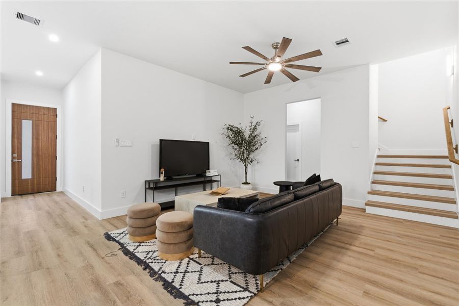 Anchored by warm wood tone floors and clean lines, the living area offers a comfortable, open space that ties seamlessly into the rest of the home.