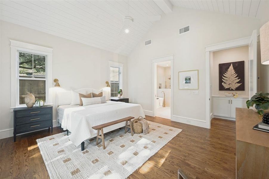 Spacious room featuring vaulted ceilings with shiplap finish, wood-finish flooring, and multiple windows with exterior views
