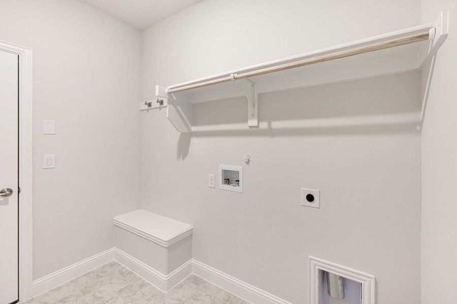 Laundry room with wall shelf, hanging rod, washer hookups, built-in bench, and pet door on tile floor Laundry room with wall shelf, hanging rod, washer hookups, built-in bench, and pet door on tile floor