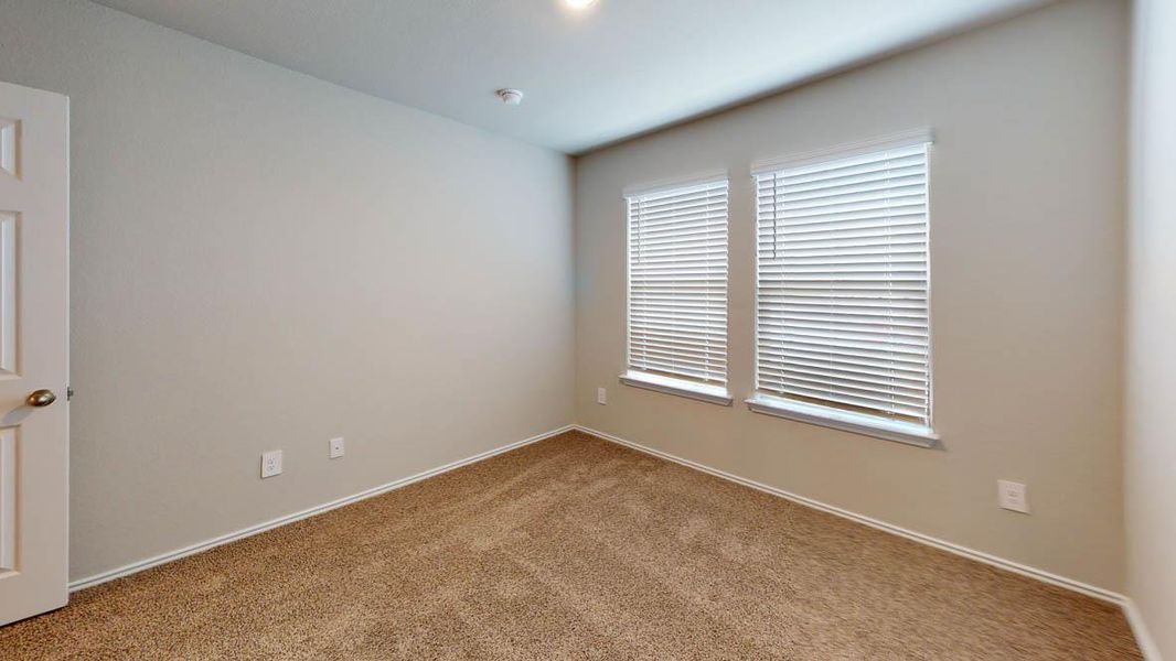 A well-lit bedroom with plush carpeting offers a blank canvas for personalization. A well-lit bedroom with plush carpeting offers a blank canvas for personalization.