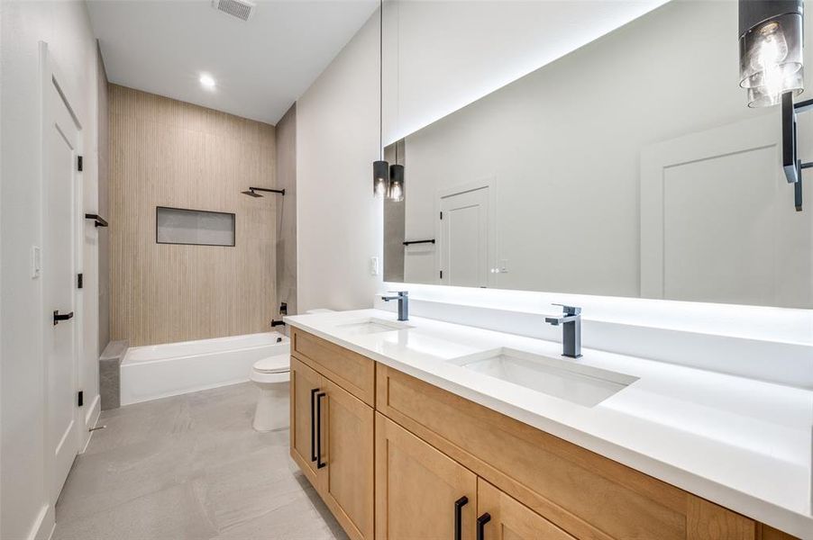 Full bath with double vanity, bathing tub / shower combination, and recessed lighting