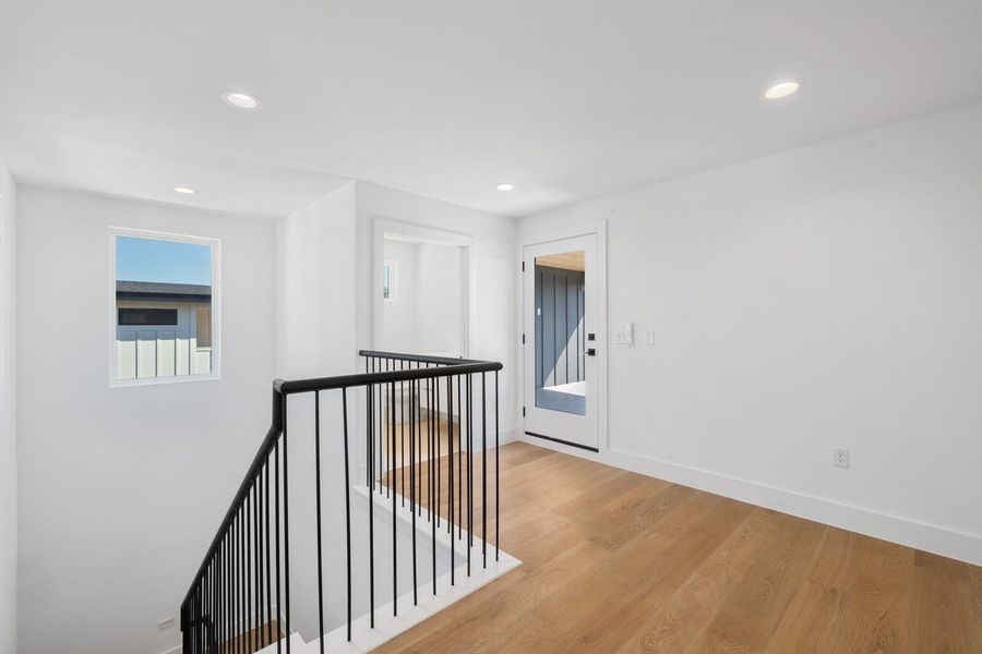 Hall featuring an upstairs landing, recessed lighting, and wood finished floors Hall featuring an upstairs landing, recessed lighting, and wood finished floors
