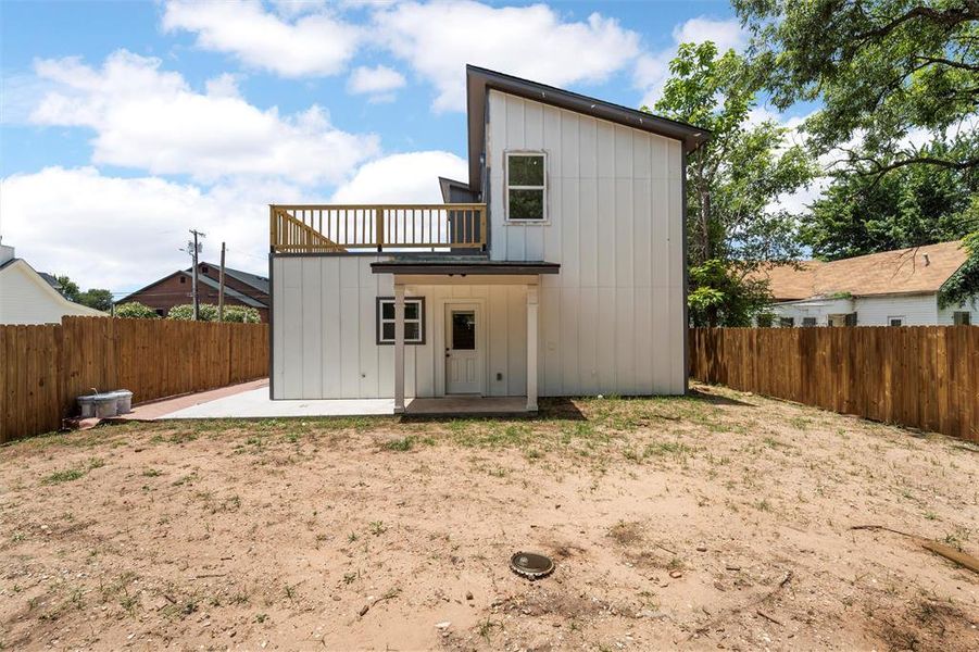 Rear view of property featuring board and batten siding, a fenced backyard, and a patio Rear view of property featuring board and batten siding, a fenced backyard, and a patio