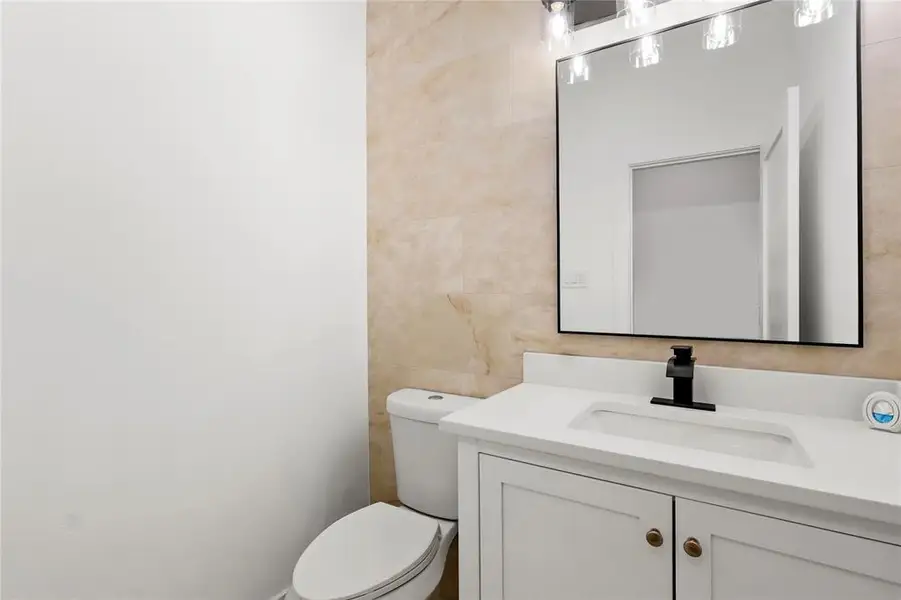 Half bath with vanity and tile walls