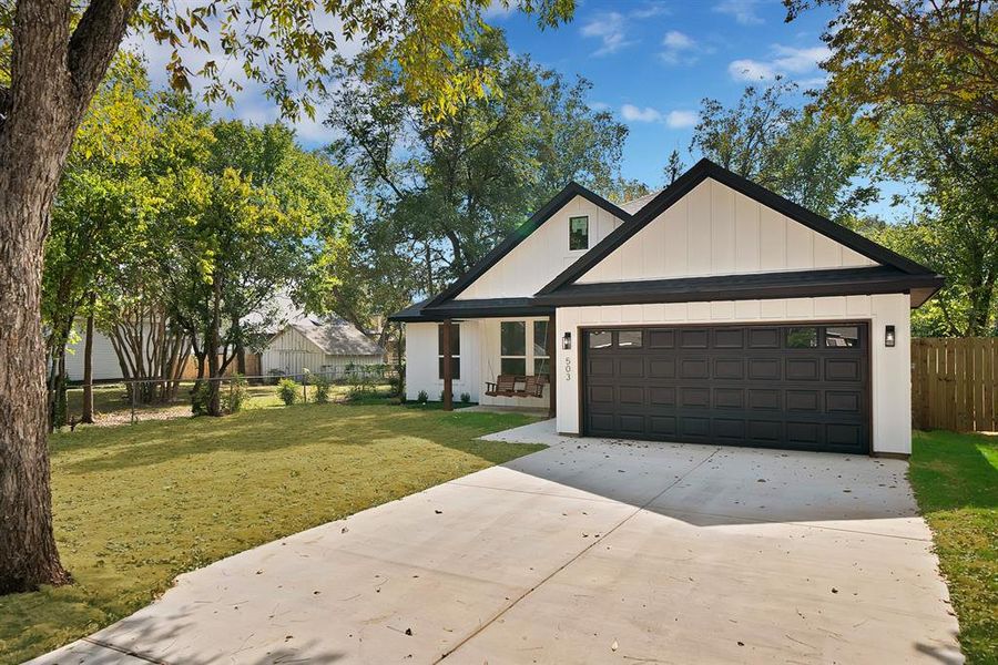 Modern inspired farmhouse featuring concrete driveway and an attached garage