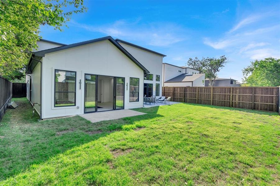 Back of house with a lawn and a patio area