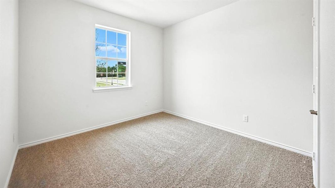 Room featuring light-colored walls, neutral carpet flooring, and white baseboards