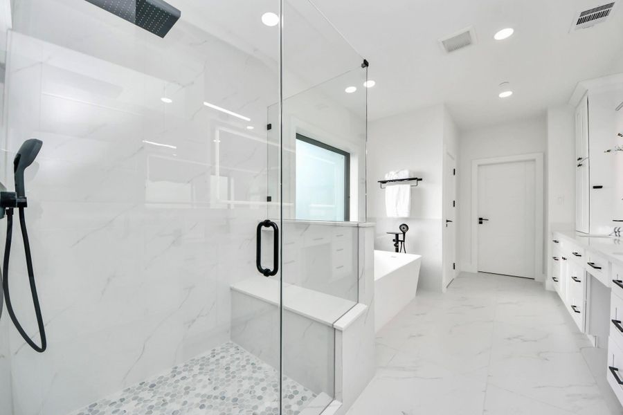 The suite seamlessly connects to a light and bright spa-inspired bathroom.