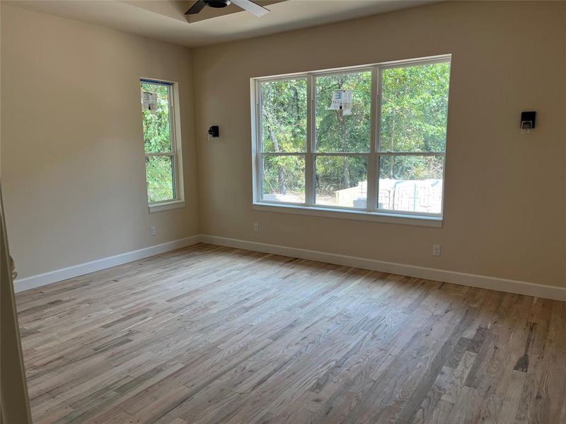 Primary suite is oversized with trey ceiling, hardwood floors, sconce lights, ensuite bath and two large walk-in closets. Primary suite is oversized with trey ceiling, hardwood floors, sconce lights, ensuite bath and two large walk-in closets.