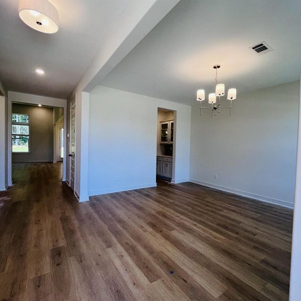 Spacious interior with wood-finish flooring, recessed lighting, and a contemporary chandelier