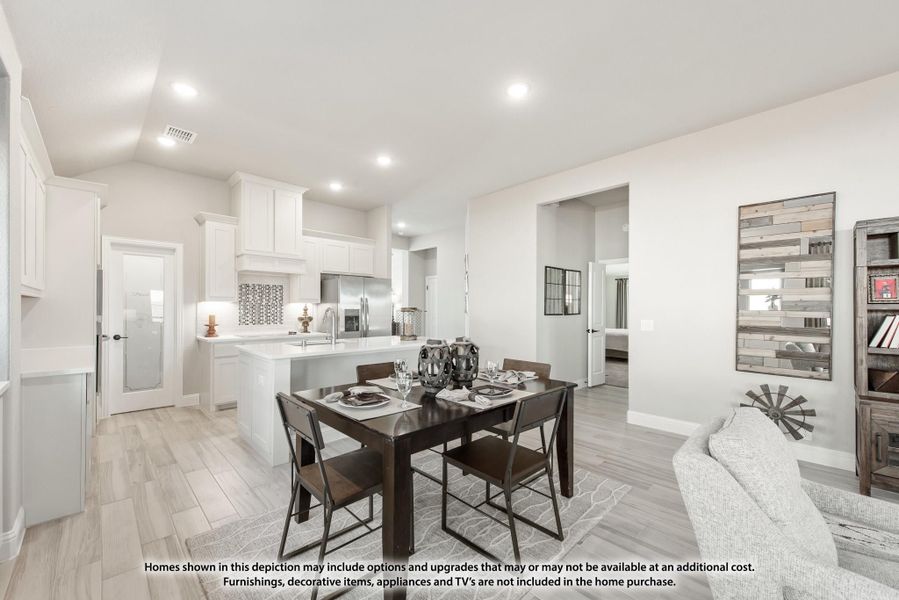 Open-concept dining area with dark wood table, white kitchen, and light wood-look tile floors